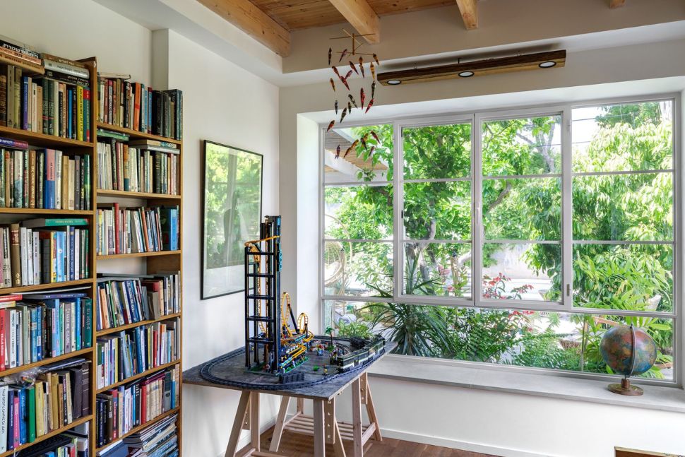ספרייה ביתית מעוצבת לצד חלון גדול