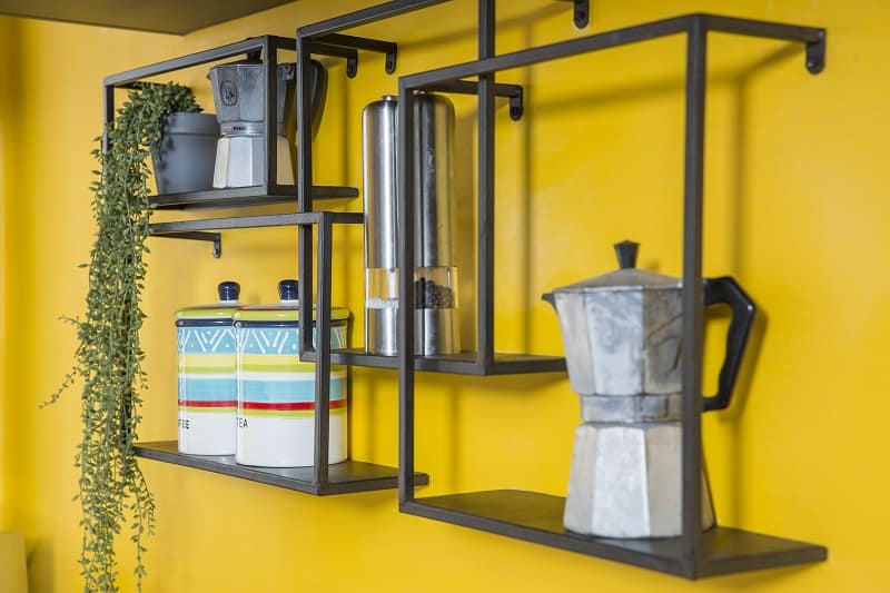 מדפי ברזל על קיר צהוב