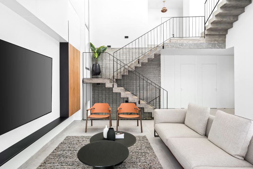 סלון ומדרגות על רקע קיר בטון