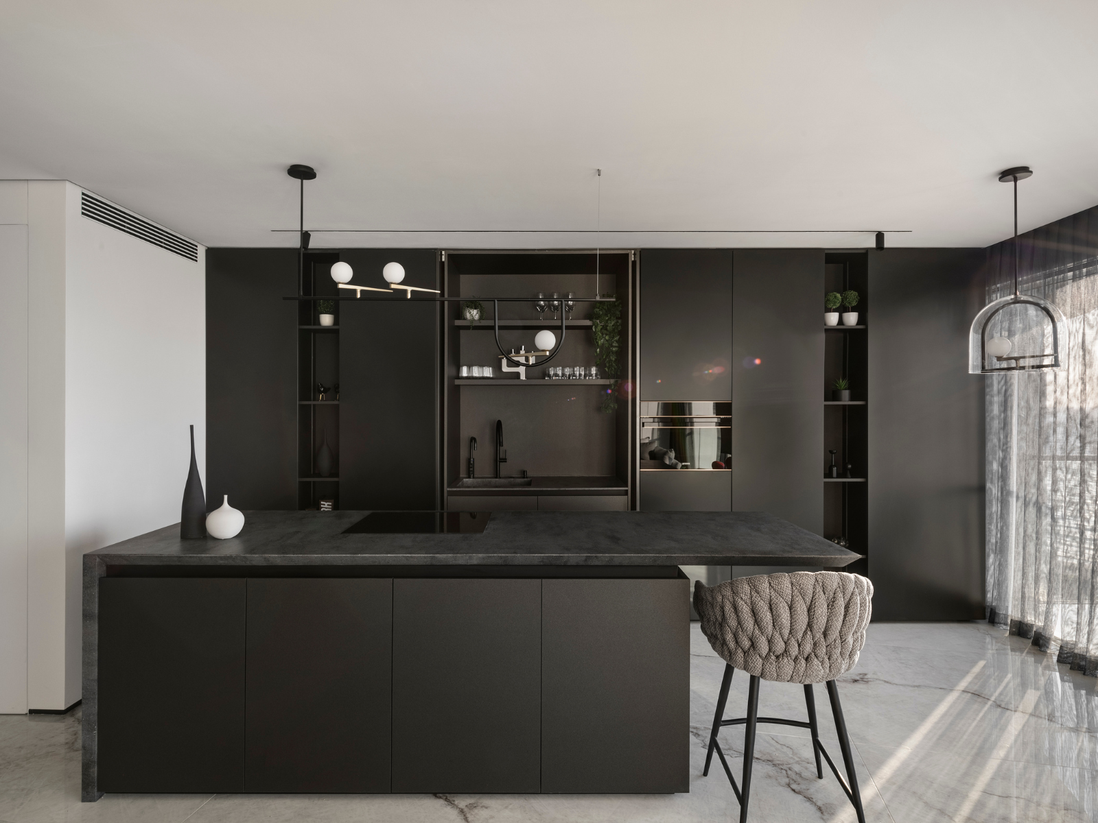 מטבח כהה ומודרני עם כסאות בר תואמים