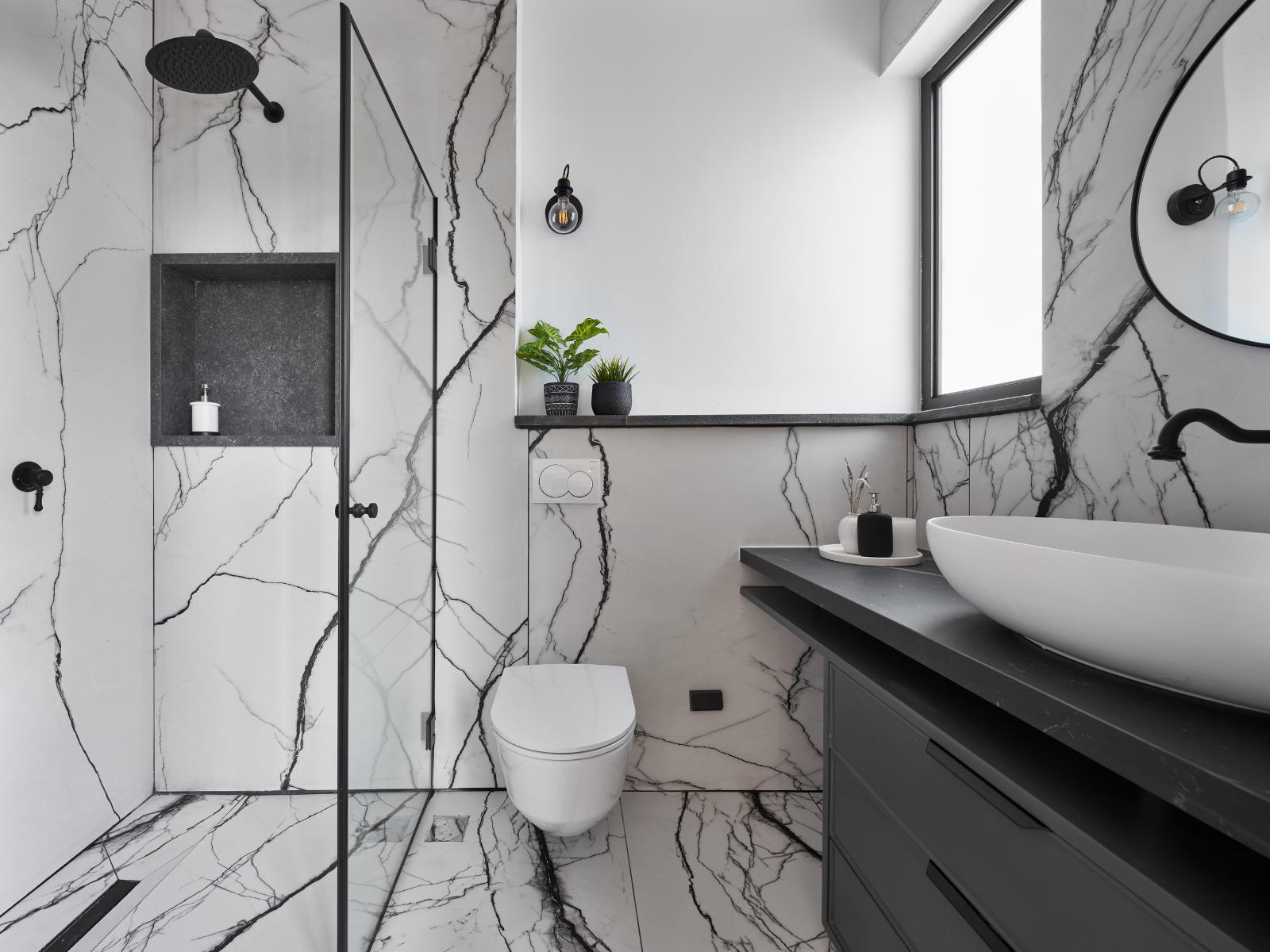 חדר הרחצה חופה באריחי שיש לבן עם גידים שחורים ודרמטיים