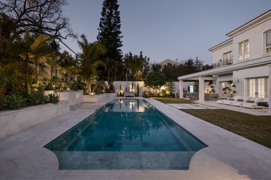 בריכת שחיה לרוחב החצר ובמקביל לחזית האחורית