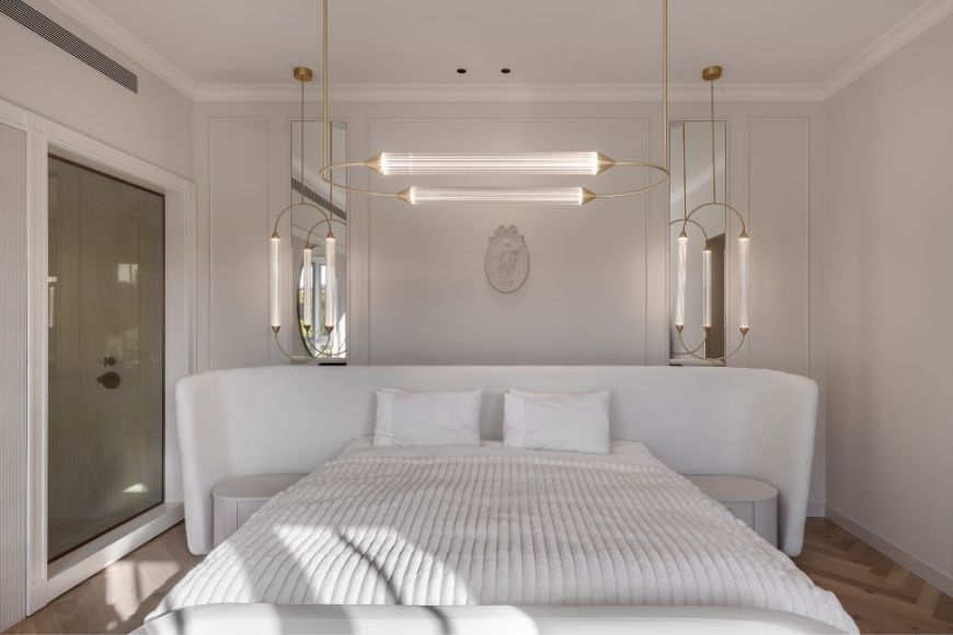 חדר שינה הורים לבן עם גב מיטה מעוגל ותאורה ייחודית