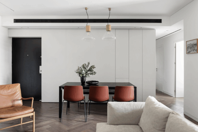 פינת אוכל מודרנית עם קיר ארונות לבן וכיסאות עור חומים